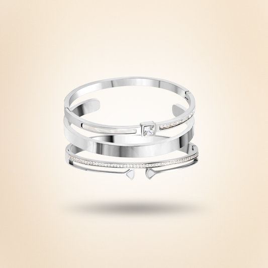 Silver bracelet stack with a diamond on a beige background