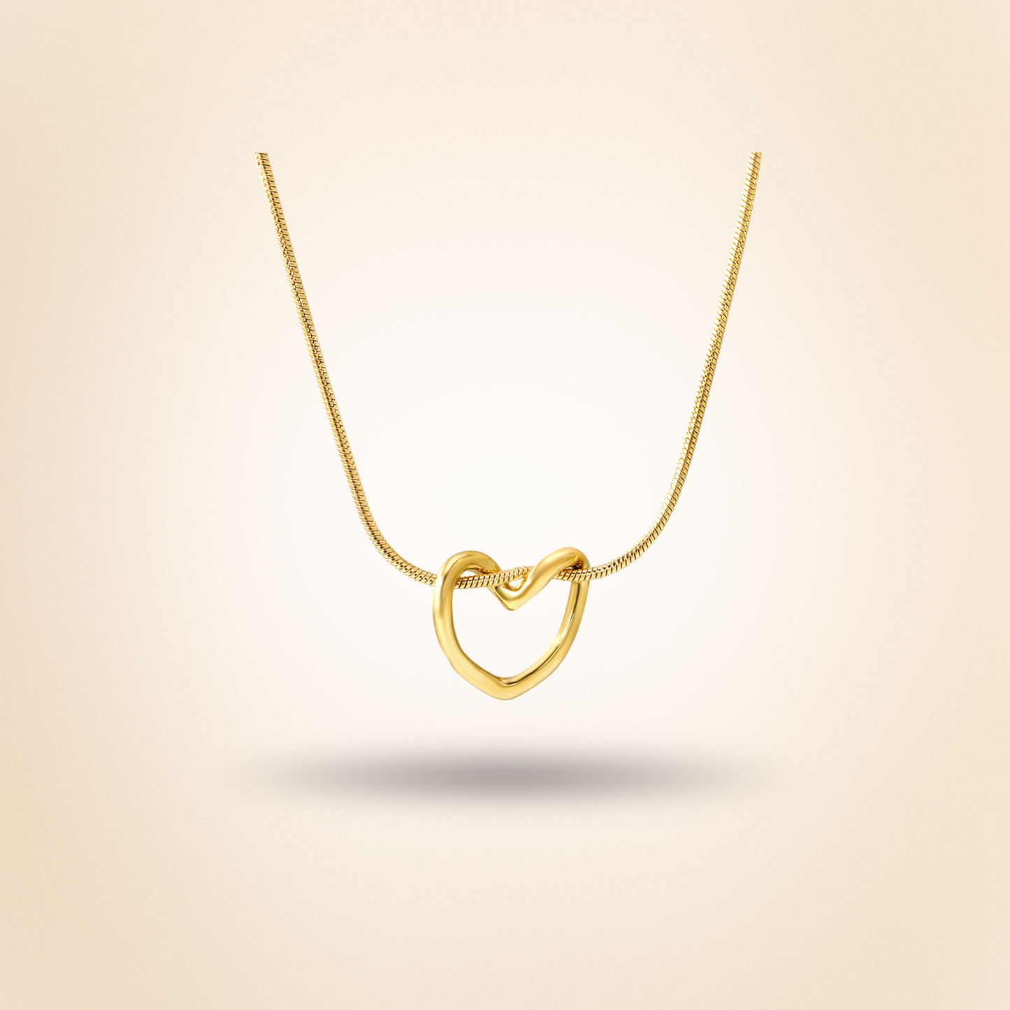 Gold heart-shaped necklace on a beige background