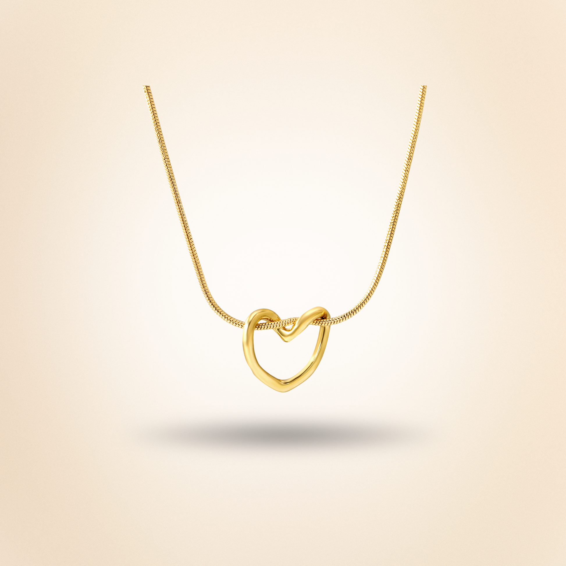 Gold heart-shaped necklace on a beige background