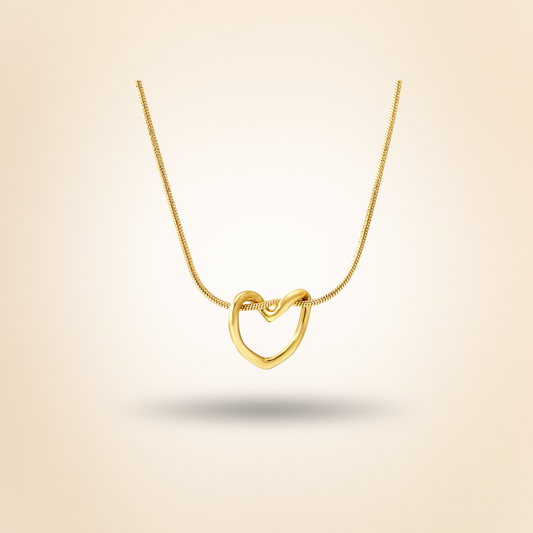 Gold heart-shaped necklace on a beige background