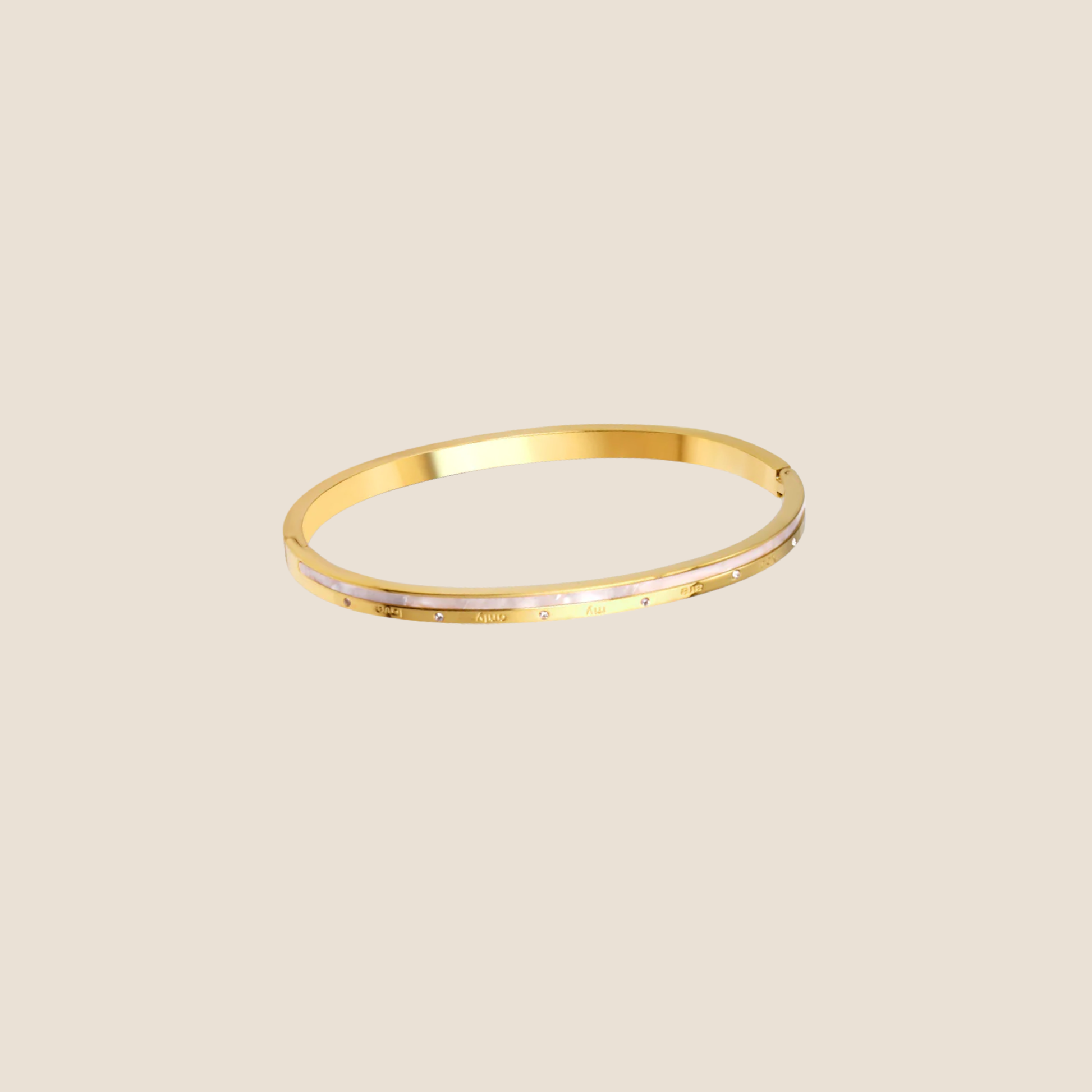 Gold bangle on a beige background