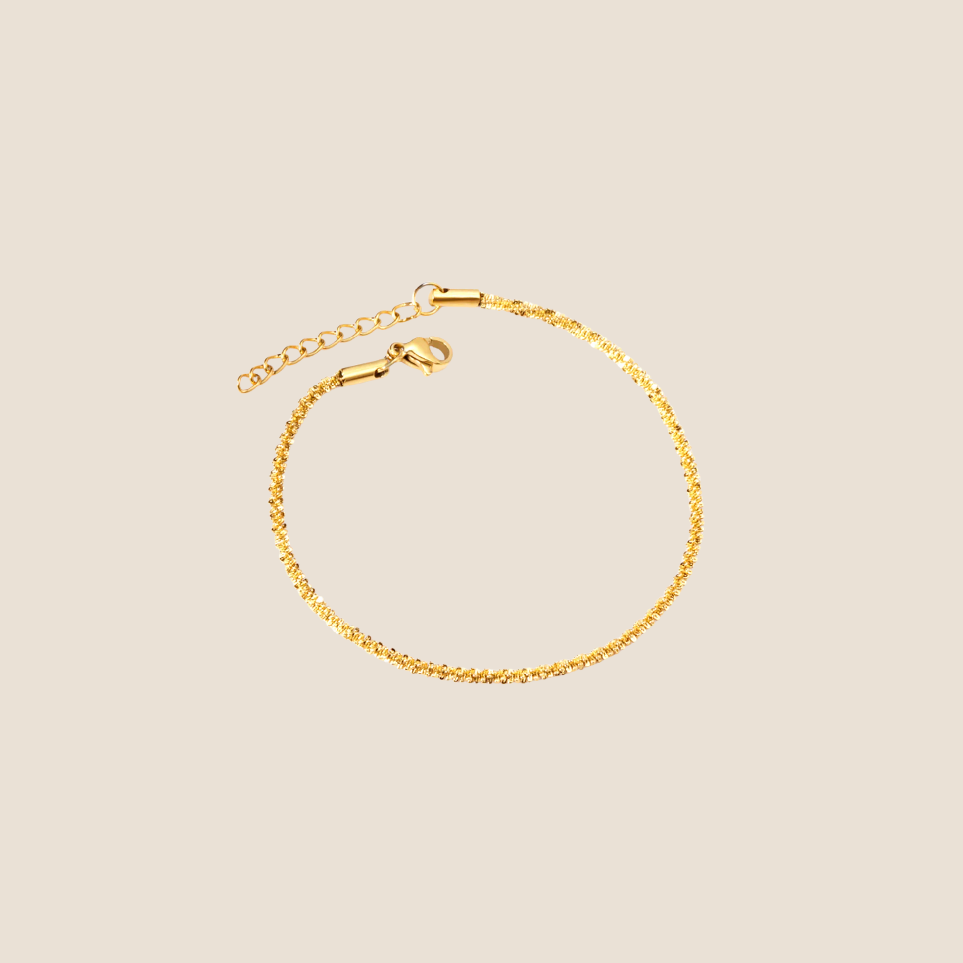 Gold bracelet on a beige background
