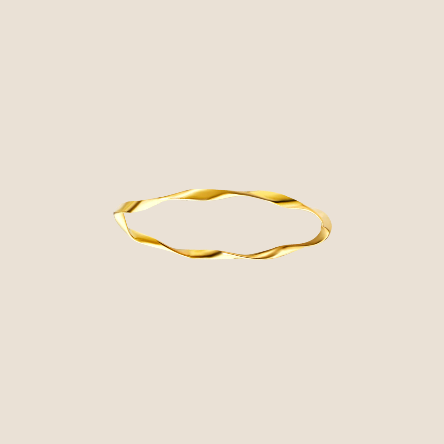 Gold ring with a wavy design on a beige background